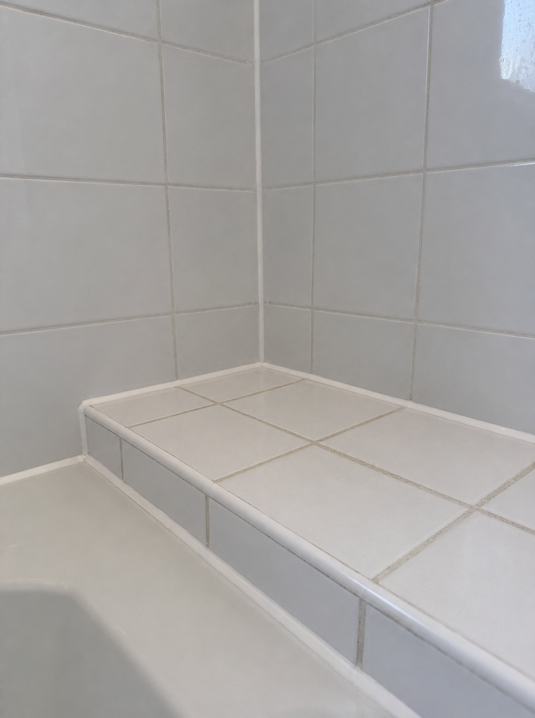 The same tiled bath surround after cleaning, preparation and a crisp new silicone bead